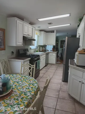 a dining room with furniture and chandelier kitchen view