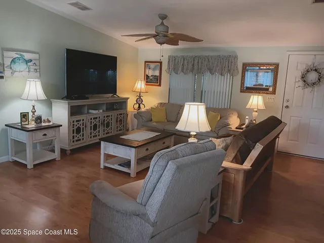 a bedroom with a large bed and a flat tv screen on dresser
