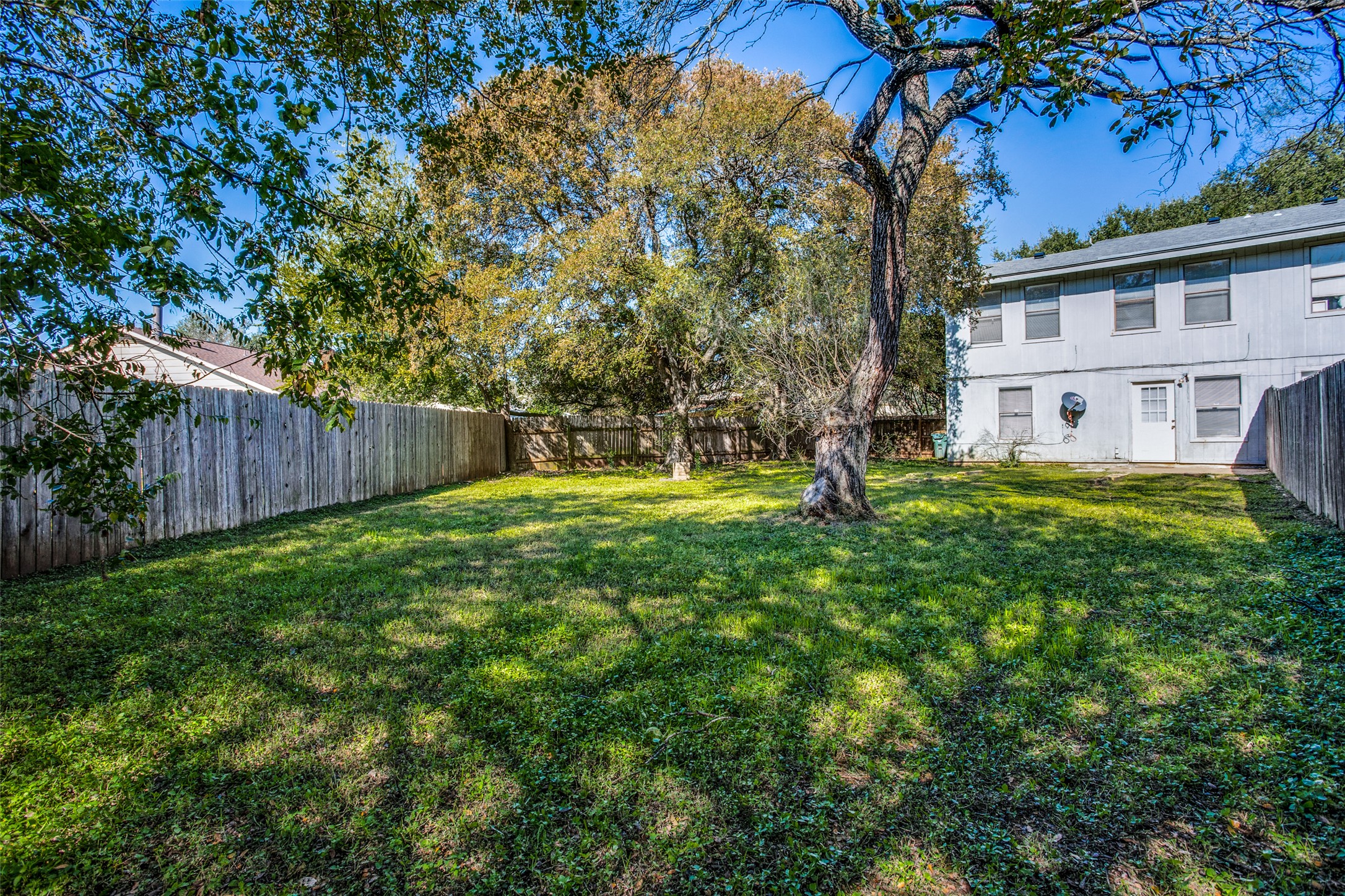 106 Verna Spur, Unit B Georgetown, TX 78628 - Photo 24 of 25 A spacious, naturally illuminated yard offers ample room for outdoor enjoyment, enclosed by wooden fencing.