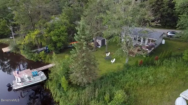 an aerial view of residential houses with outdoor space and trees