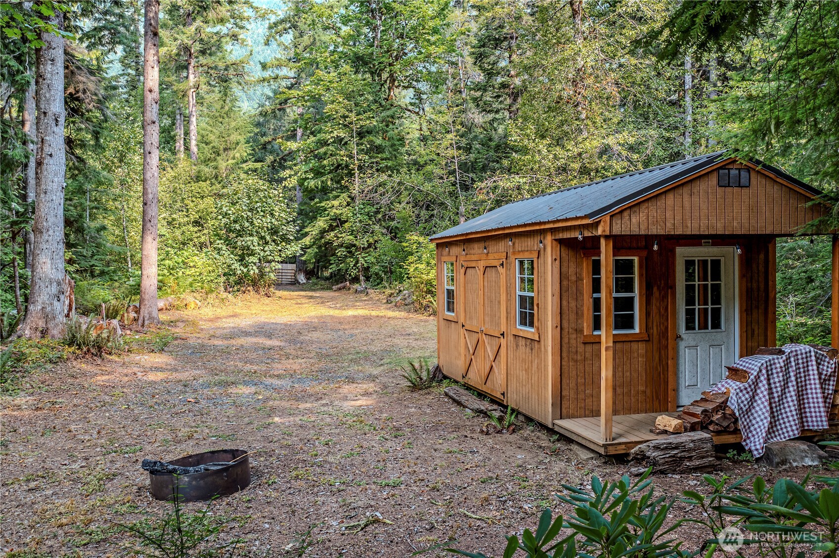 a view of a small house with yard and sitting area