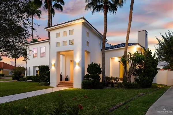 a view of a house with a yard and palm trees