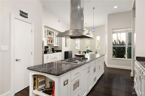 a kitchen with stainless steel appliances granite countertop a stove a sink and a refrigerator