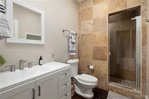 a bathroom with a sink a toilet and shower