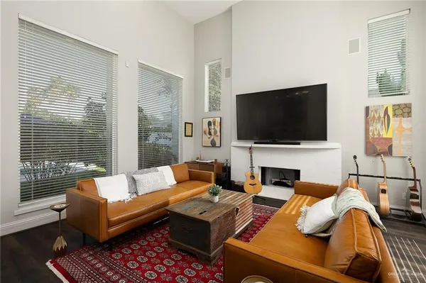 a living room with a couch a flat screen tv and a large window
