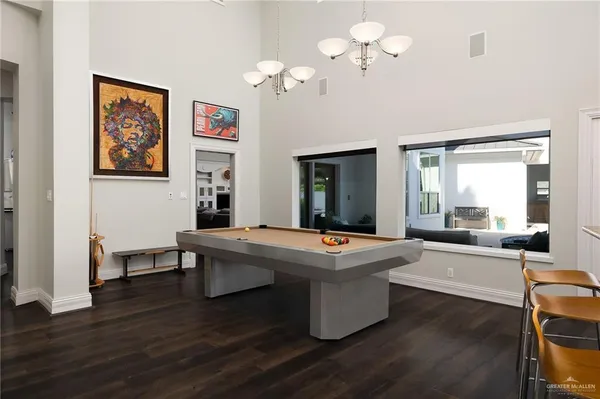 a view of a dining room with furniture a chandelier and wooden floor