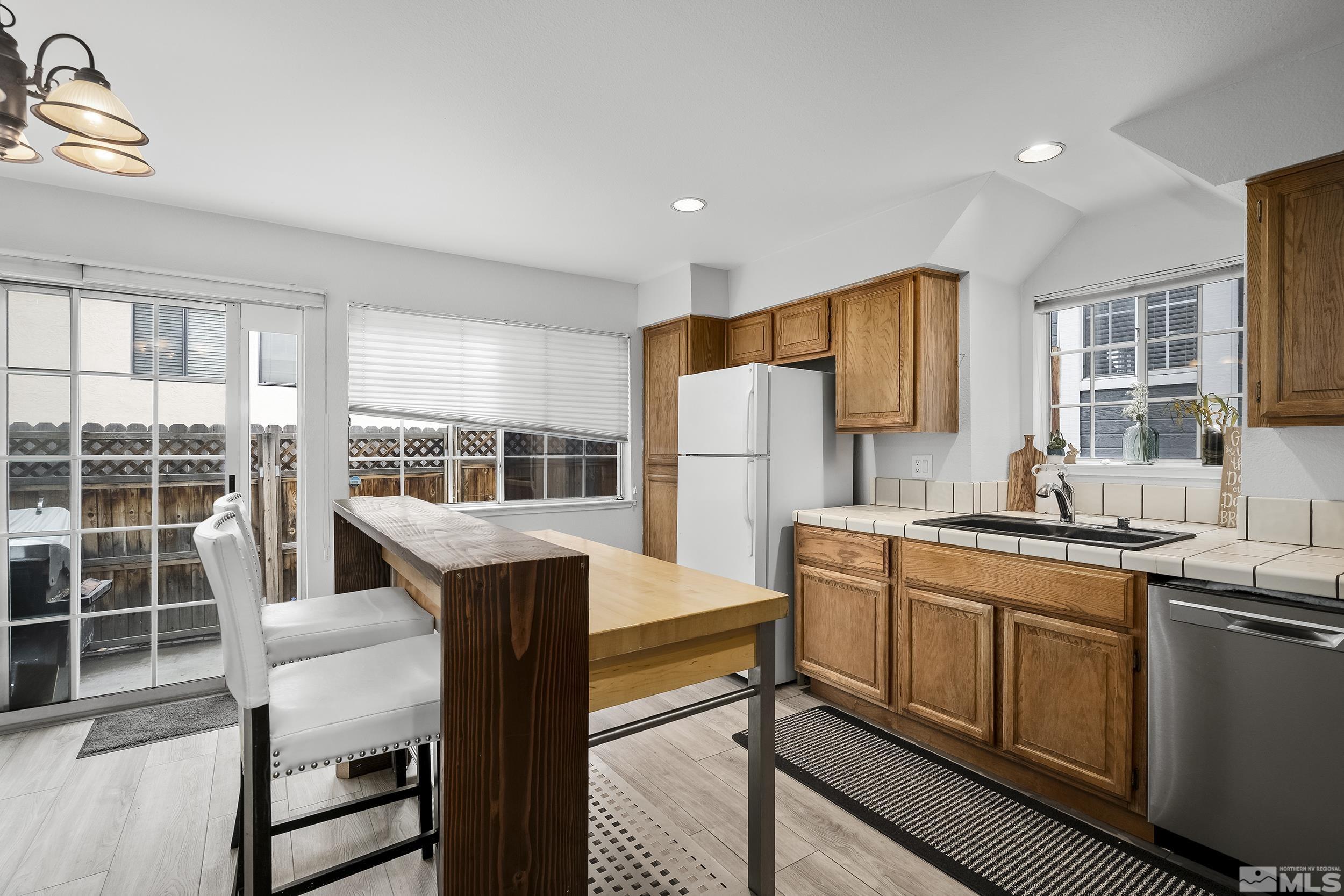 2650 Plumas Street, Unit 13 Reno, NV 89509 - Photo 9 of 23 a kitchen with stainless steel appliances a stove a refrigerator a sink and dishwasher with wooden floor