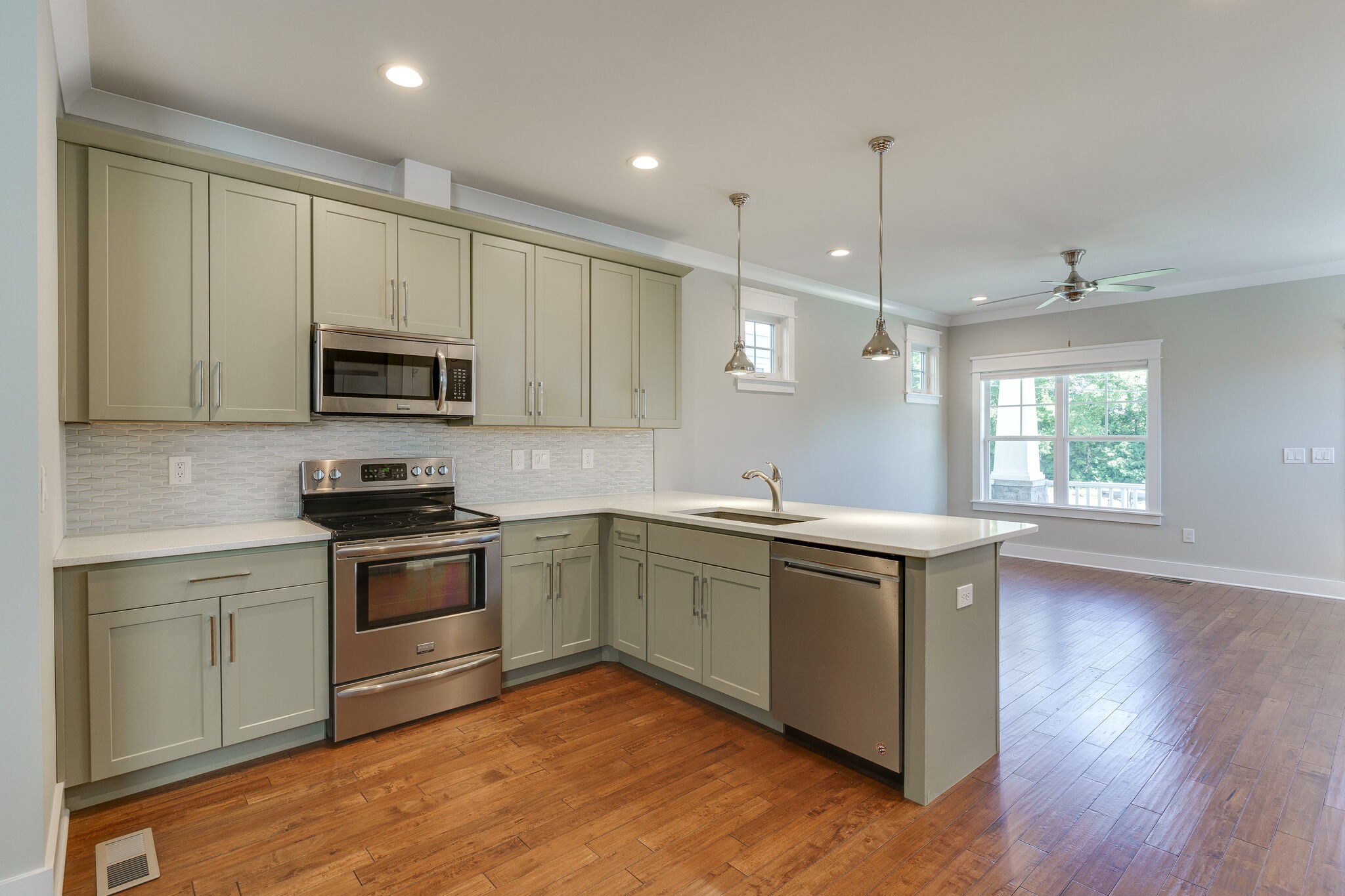 1711 Ridley Boulevard Nashville, TN 37203 - Photo 12 of 49 a kitchen with kitchen island granite countertop a sink cabinets and wooden floor
