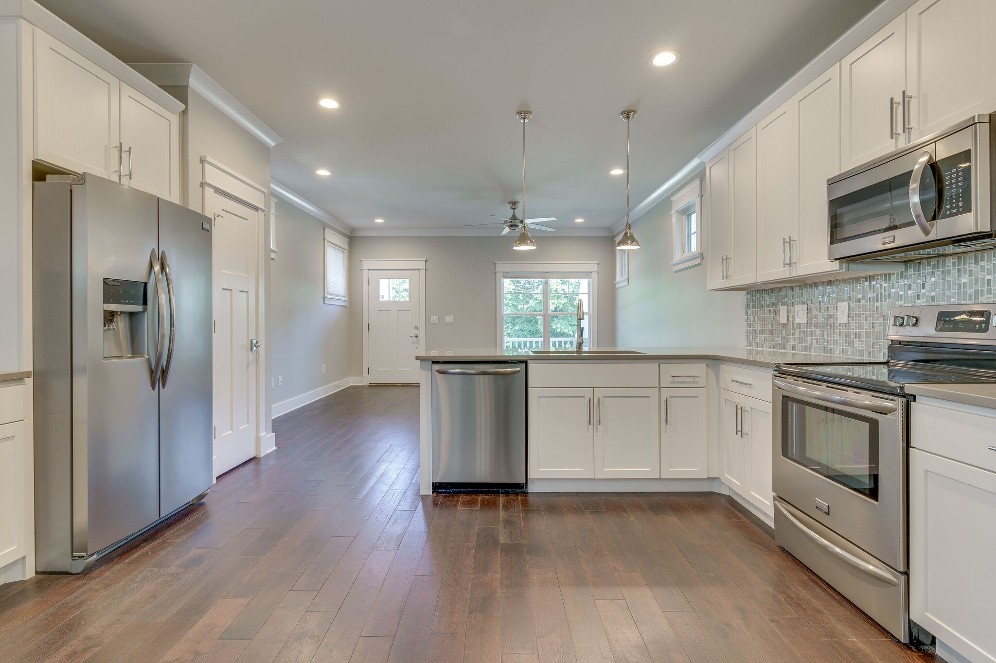 1711 Ridley Boulevard Nashville, TN 37203 - Photo 35 of 49 a kitchen with stainless steel appliances granite countertop a refrigerator a sink dishwasher a stove and white cabinets with wooden floor