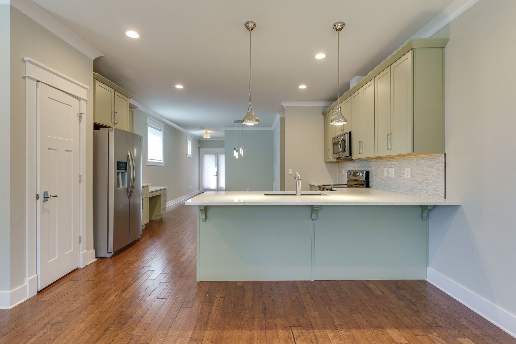 1711 Ridley Boulevard Nashville, TN 37203 - Photo 9 of 49 a large kitchen with stainless steel appliances a large counter top a sink and a refrigerator
