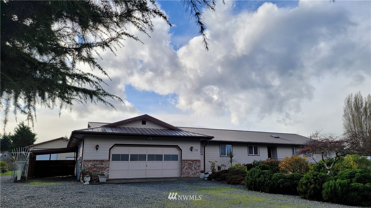 171 Mantle Road Sequim, WA 98382 - Photo 2 of 34 a front view of a house with a garden