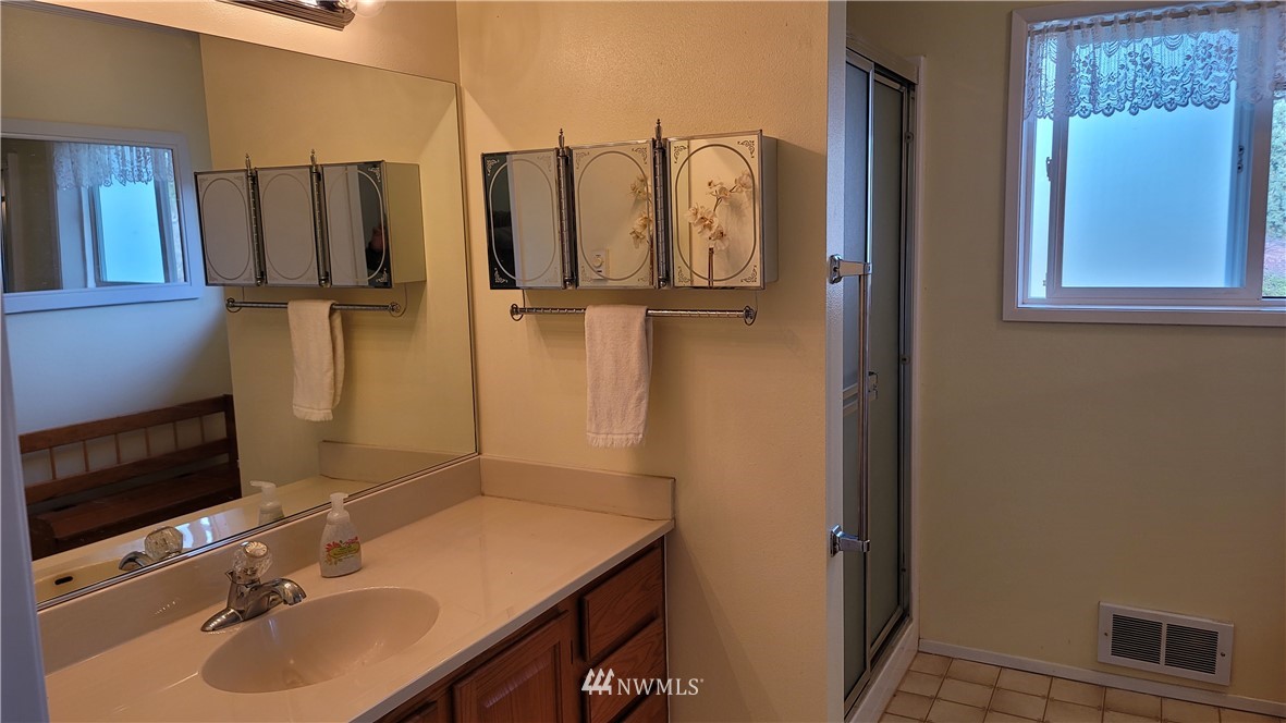 171 Mantle Road Sequim, WA 98382 - Photo 14 of 34 a bathroom with a sink vanity and mirror