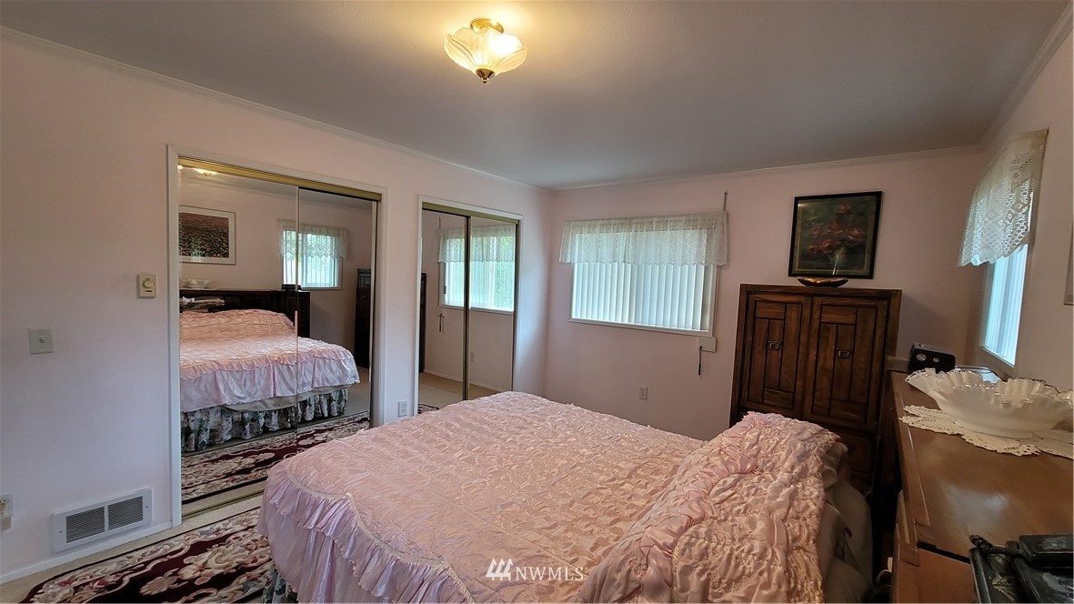 171 Mantle Road Sequim, WA 98382 - Photo 9 of 34 a bedroom with a bed and wooden floor