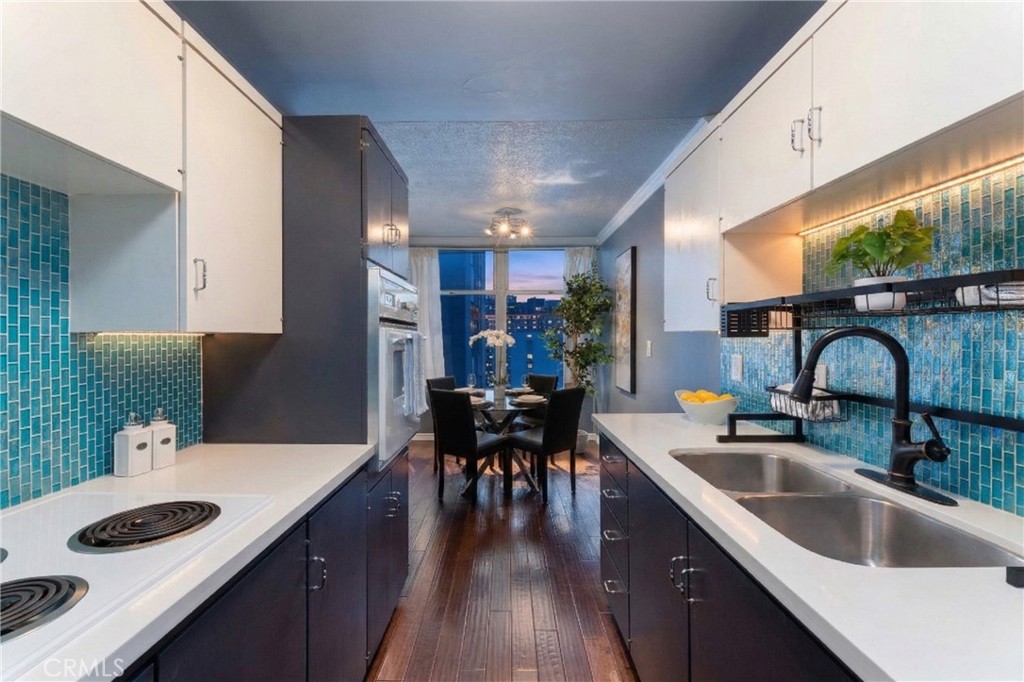 100 Atlantic Avenue, Unit 902 Long Beach, CA 90802 - Photo 3 of 28 a kitchen with kitchen island a sink table and chairs