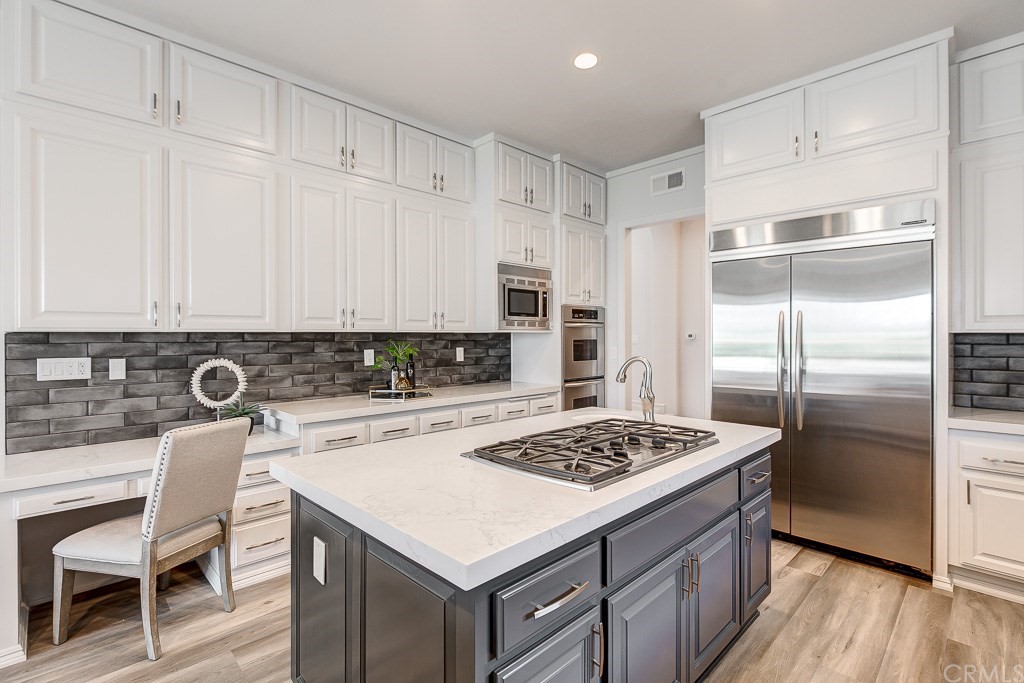 11 Marbella Dana Point, CA 92629 - Photo 15 of 50 a kitchen with a refrigerator a stove a sink and white cabinets