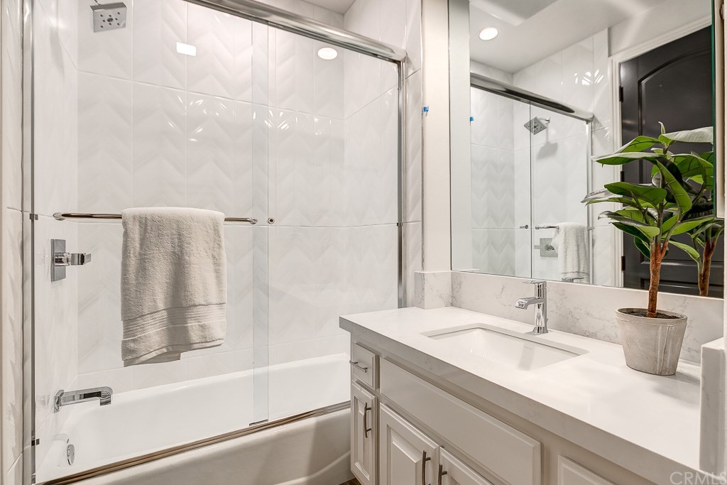 11 Marbella Dana Point, CA 92629 - Photo 22 of 50 a bathroom with a granite countertop sink a mirror a shower and a bathtub