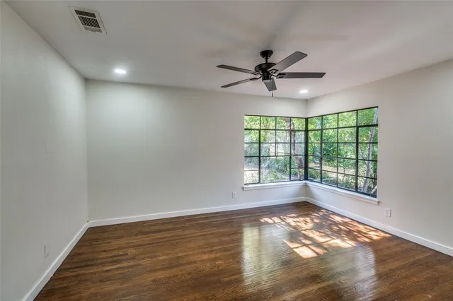 an empty room with a ceiling fan and a window