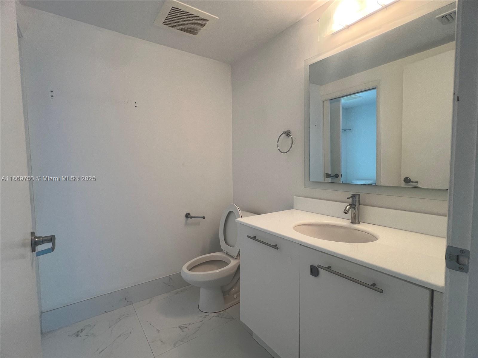 92 Southwest 3rd Street, Unit 3803 Miami, FL 33130 - Photo 22 of 31 a bathroom with a sink and mirror with toilet