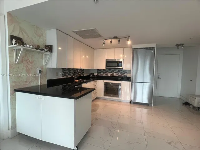 a kitchen with stainless steel appliances a sink stove and refrigerator