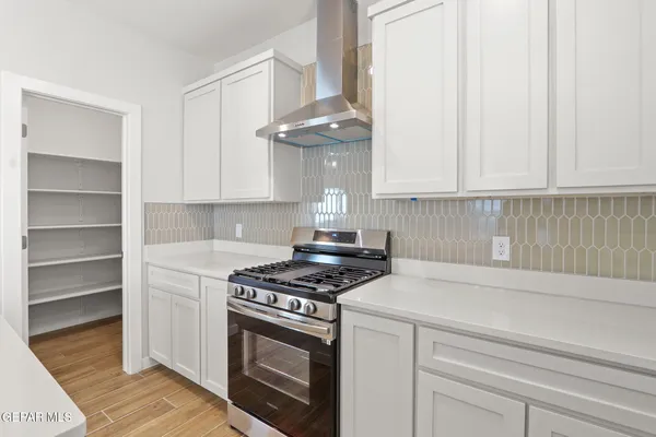 a kitchen with stainless steel appliances granite countertop a stove a white cabinet and a granite countertops with cabinets