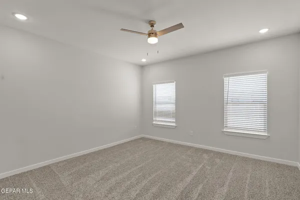 an empty room with a window and a ceiling fan