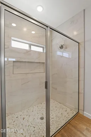a bathroom with a glass shower door and mirror
