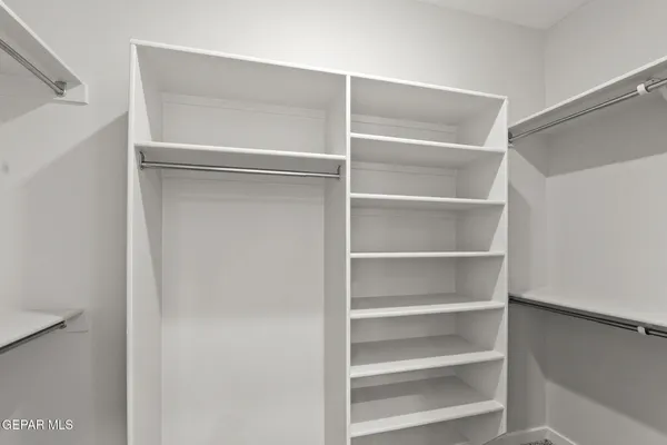 a view of walk in closet with empty racks