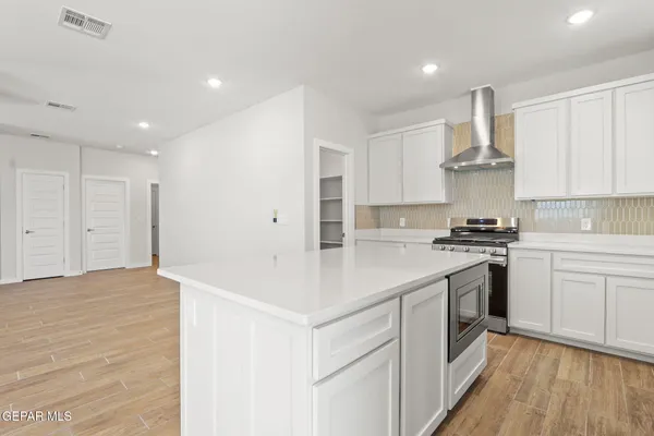 a kitchen with a stove and white cabinets