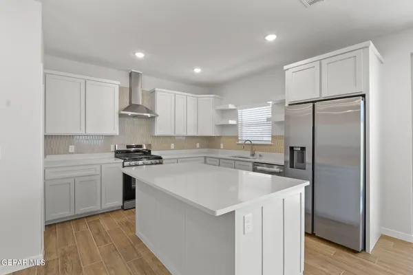a kitchen with a refrigerator a sink and cabinets