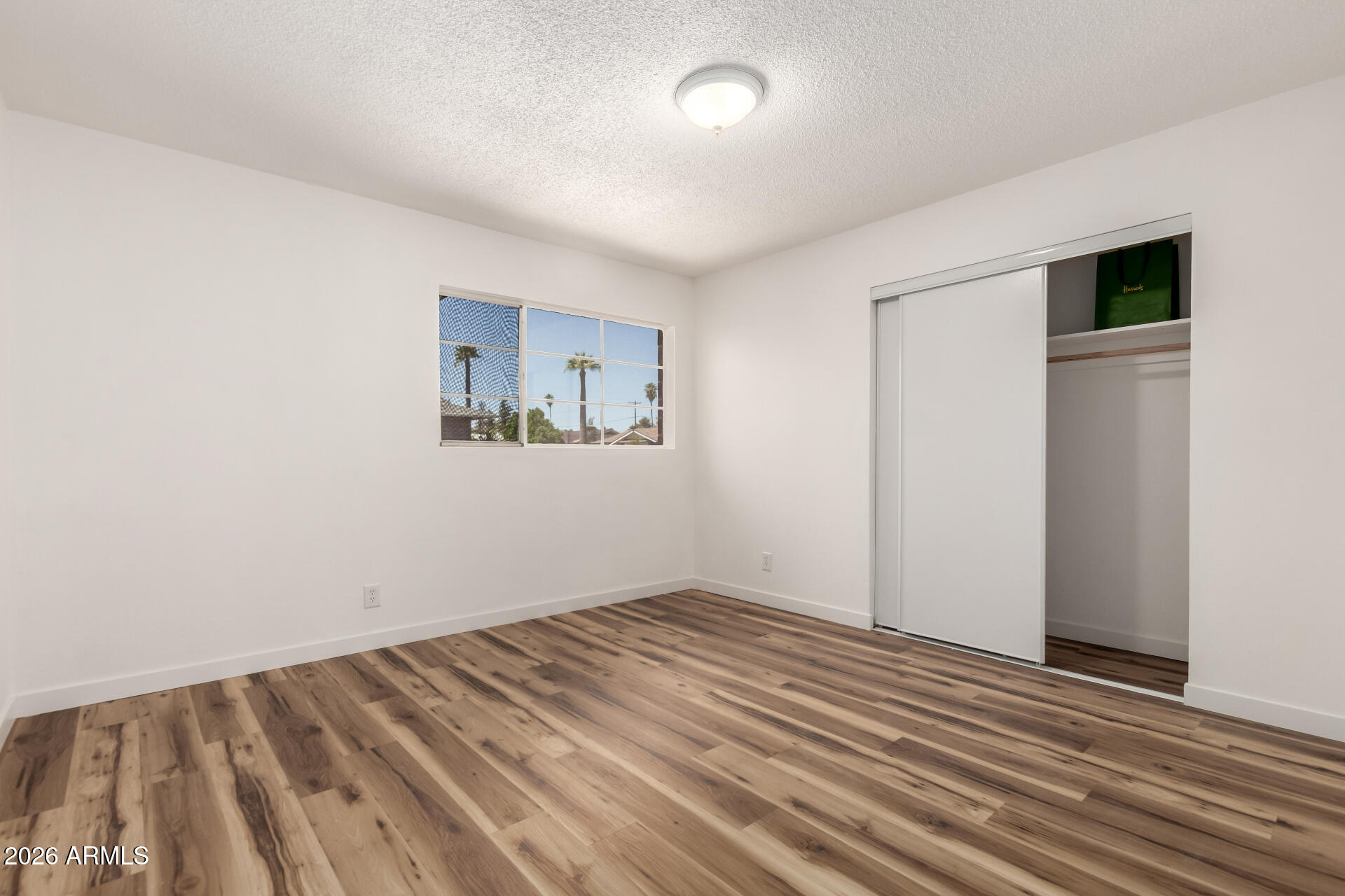3913 West Krall Street Phoenix, AZ 85019 - Photo 25 of 35 an empty room with wooden floor and windows
