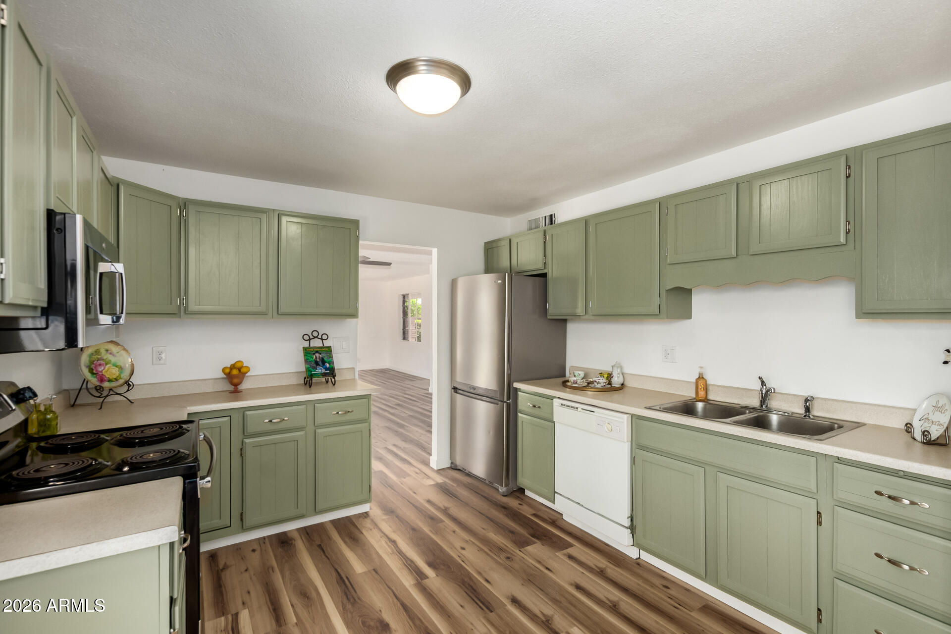 3913 West Krall Street Phoenix, AZ 85019 - Photo 3 of 35 a kitchen with stainless steel appliances a sink stove and refrigerator