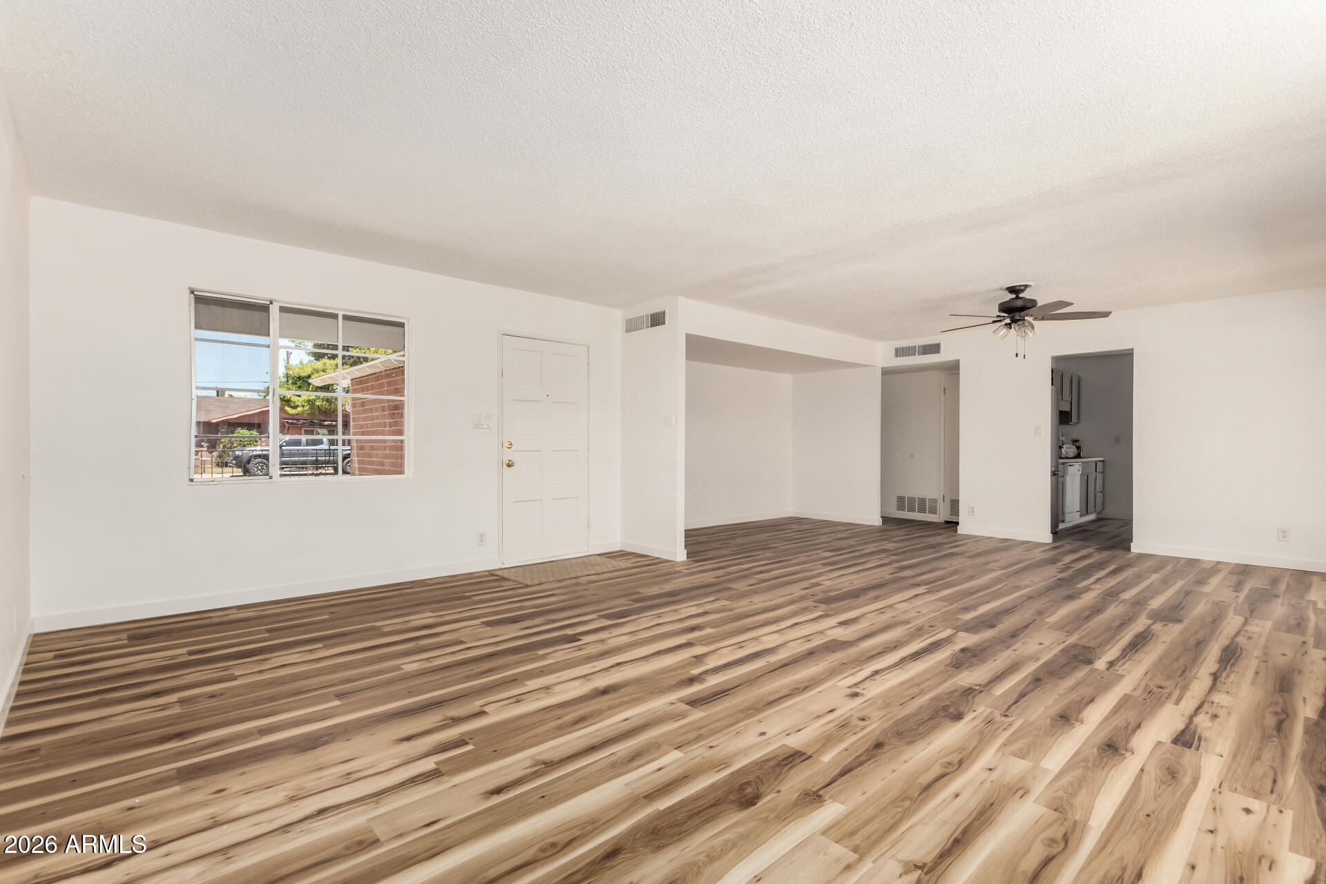 3913 West Krall Street Phoenix, AZ 85019 - Photo 5 of 35 a view of empty room with wooden floor and fan