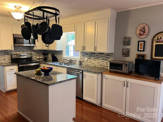 a kitchen with stainless steel appliances granite countertop a sink stove and cabinets