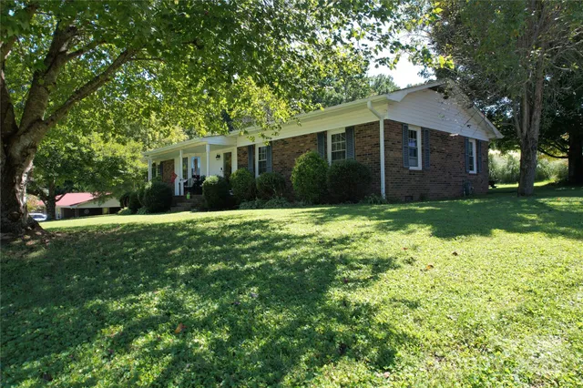 a view of a house with yard and tree s