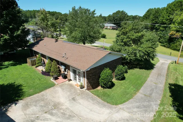 an aerial view of a house with yard and green space