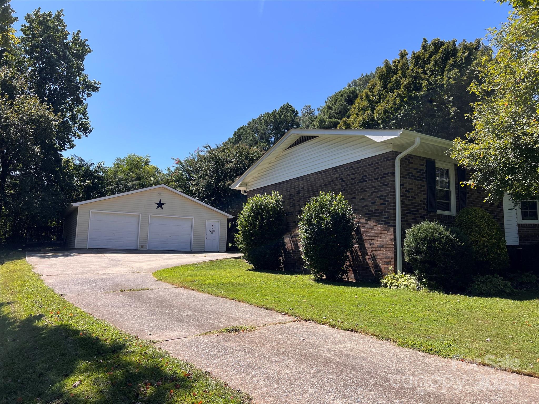 38430 Airport Road Albemarle, NC 28001 - Photo 5 of 39 a view of a back yard with flower plants and a large tree