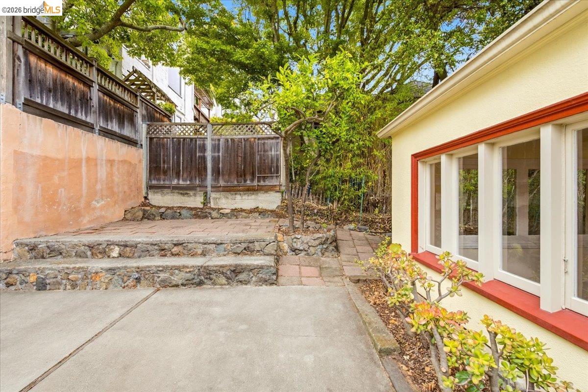 2403 Cedar Street Berkeley, CA 94708 - Photo 33 of 33 Rear exterior featuring a stucco facade with white-framed windows, a red trim accent, and a concrete patio