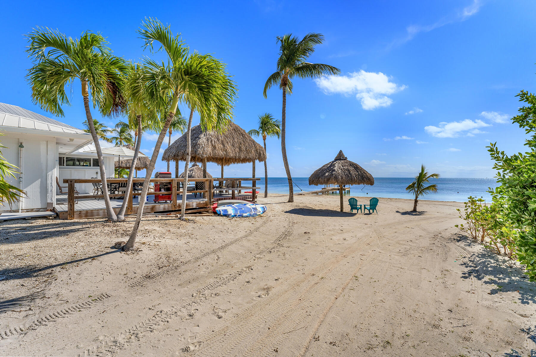 65620 Overseas Highway Long Key, FL 33001 - Photo 12 of 65 a view of patio with a table and chairs under an umbrella with palm trees