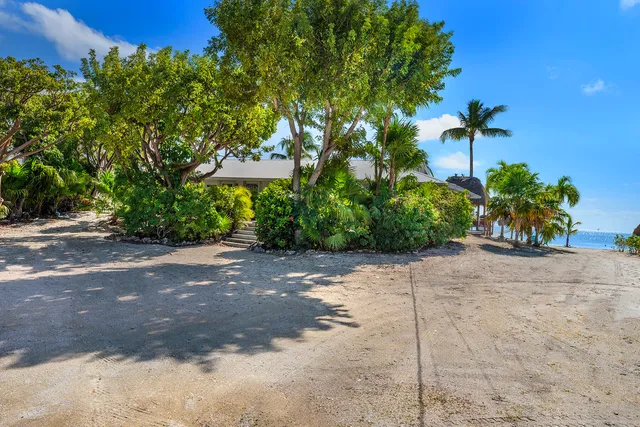a living room with stainless steel appliances furniture a rug and a kitchen view