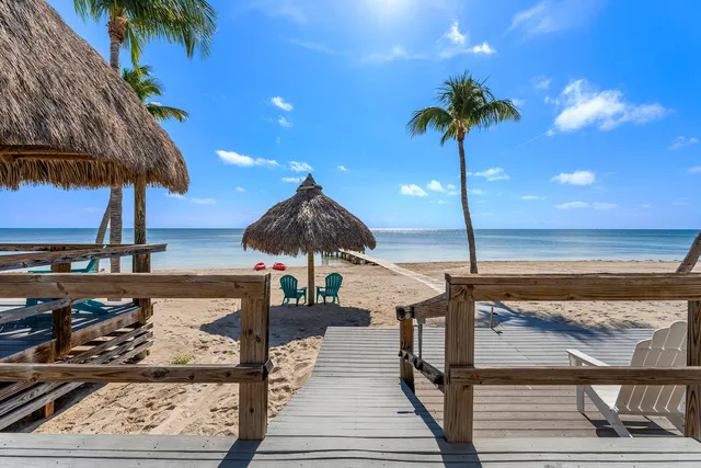 a bedroom with a bed a dresser and next to a window