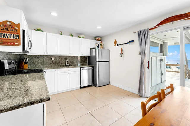 a view of a patio with table and chairs under an umbrella with wooden floor