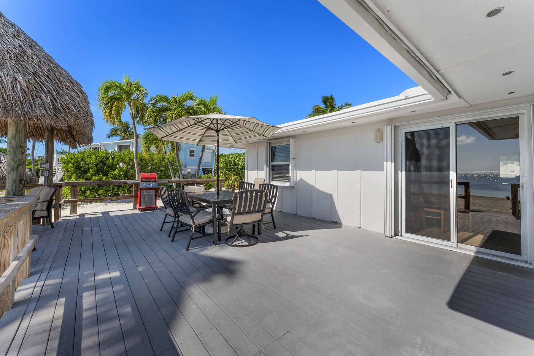 65620 Overseas Highway Long Key, FL 33001 - Photo 53 of 65 a view of a patio with table and chairs under an umbrella with wooden floor