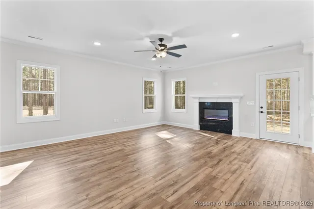 a view of empty room with fireplace and wooden floor