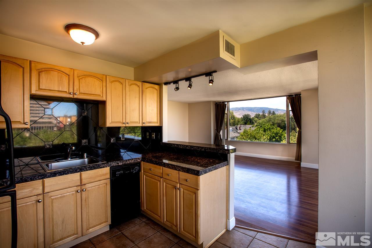 280 Island, Unit 703 Reno, NV 89501 - Photo 11 of 34 a kitchen with granite countertop a stove a sink and a microwave