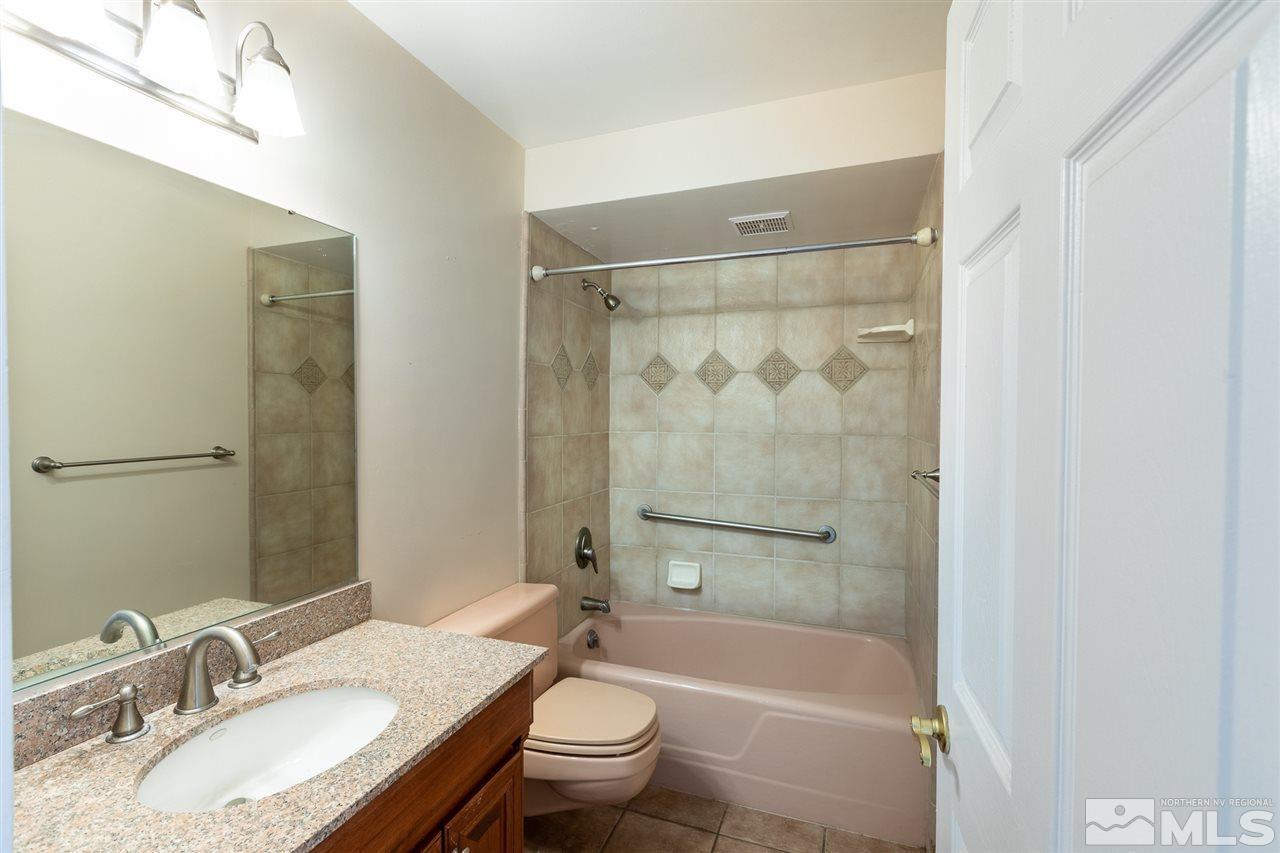 280 Island, Unit 703 Reno, NV 89501 - Photo 22 of 34 a bathroom with a granite countertop toilet a sink and a bathtub