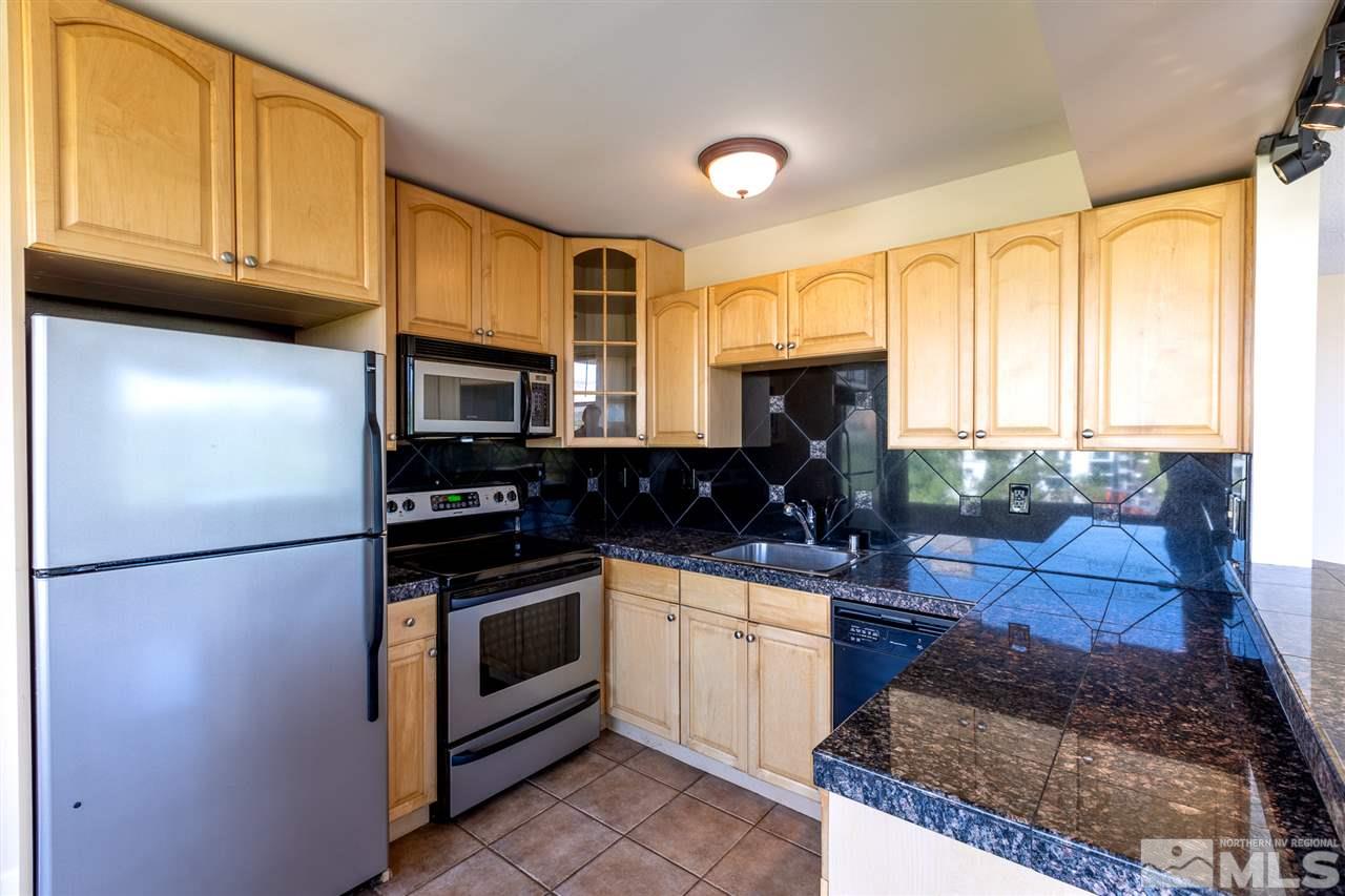 280 Island, Unit 703 Reno, NV 89501 - Photo 10 of 34 a kitchen with stainless steel appliances granite countertop a refrigerator sink and cabinets