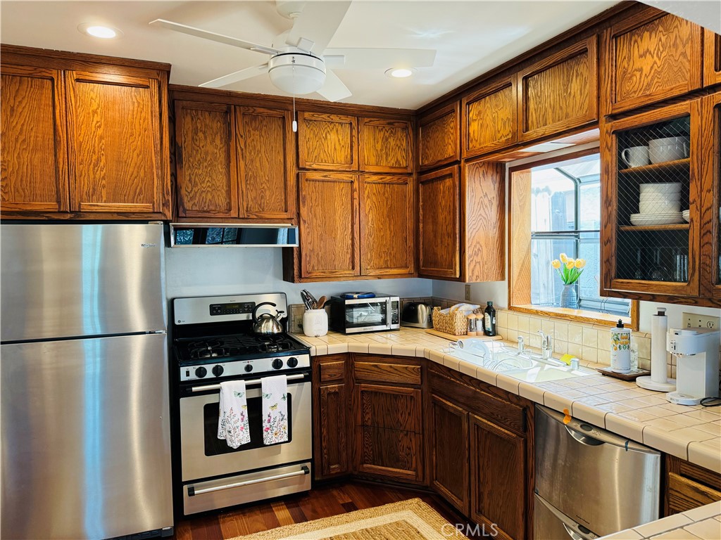 87 Rivo Alto Canal Long Beach, CA 90803 - Photo 8 of 34 a kitchen with stainless steel appliances granite countertop a refrigerator a sink dishwasher a stove and white countertops with wooden floor