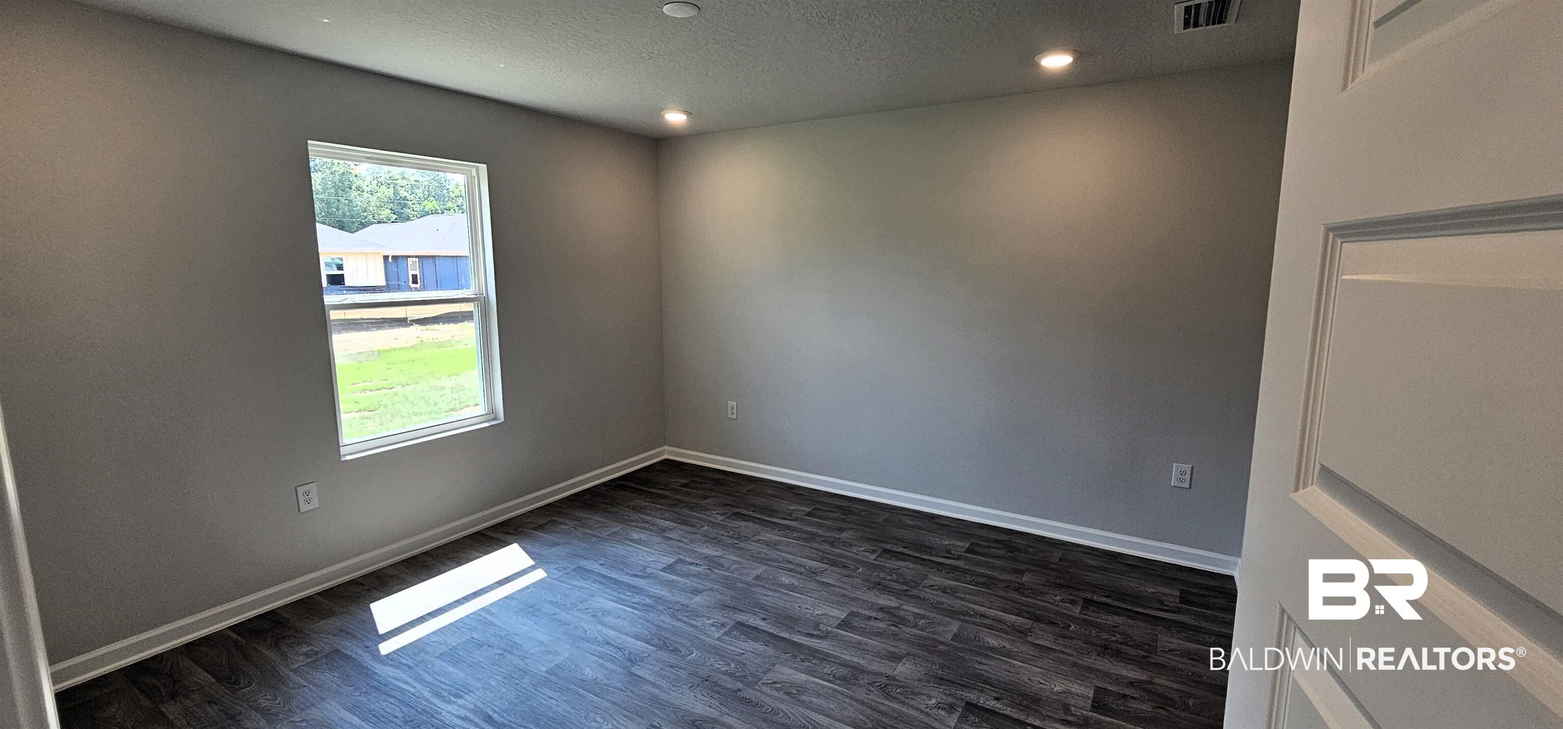 1144 Sweet Laurel Street Foley, AL 36535 - Photo 2 of 10 Empty room featuring dark hardwood / wood-style flooring and a textured ceiling