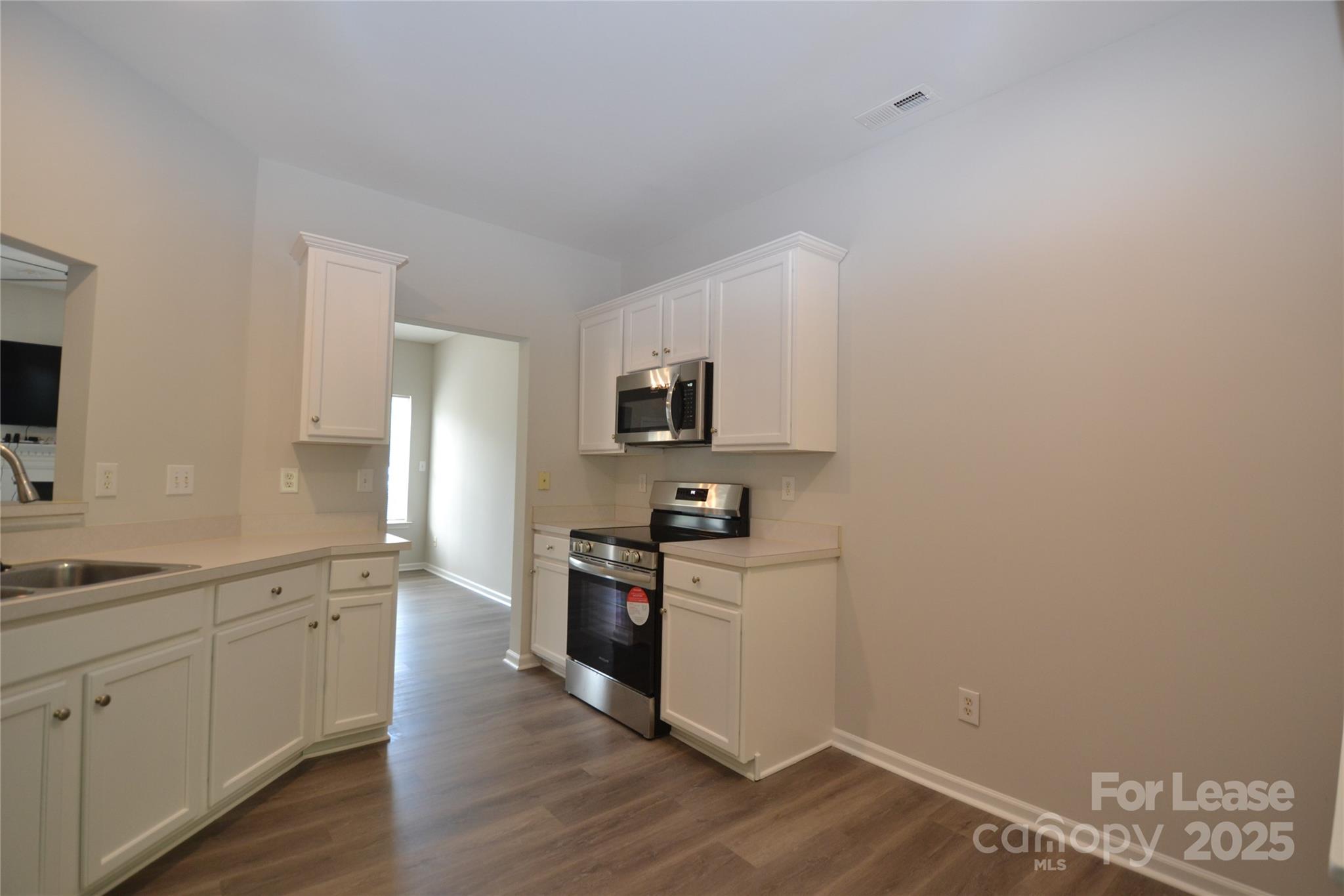 9647 Bailey Road Cornelius, NC 28031 - Photo 7 of 29 a kitchen with a sink cabinets and wooden floor