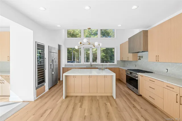 an empty room with windows and fireplace